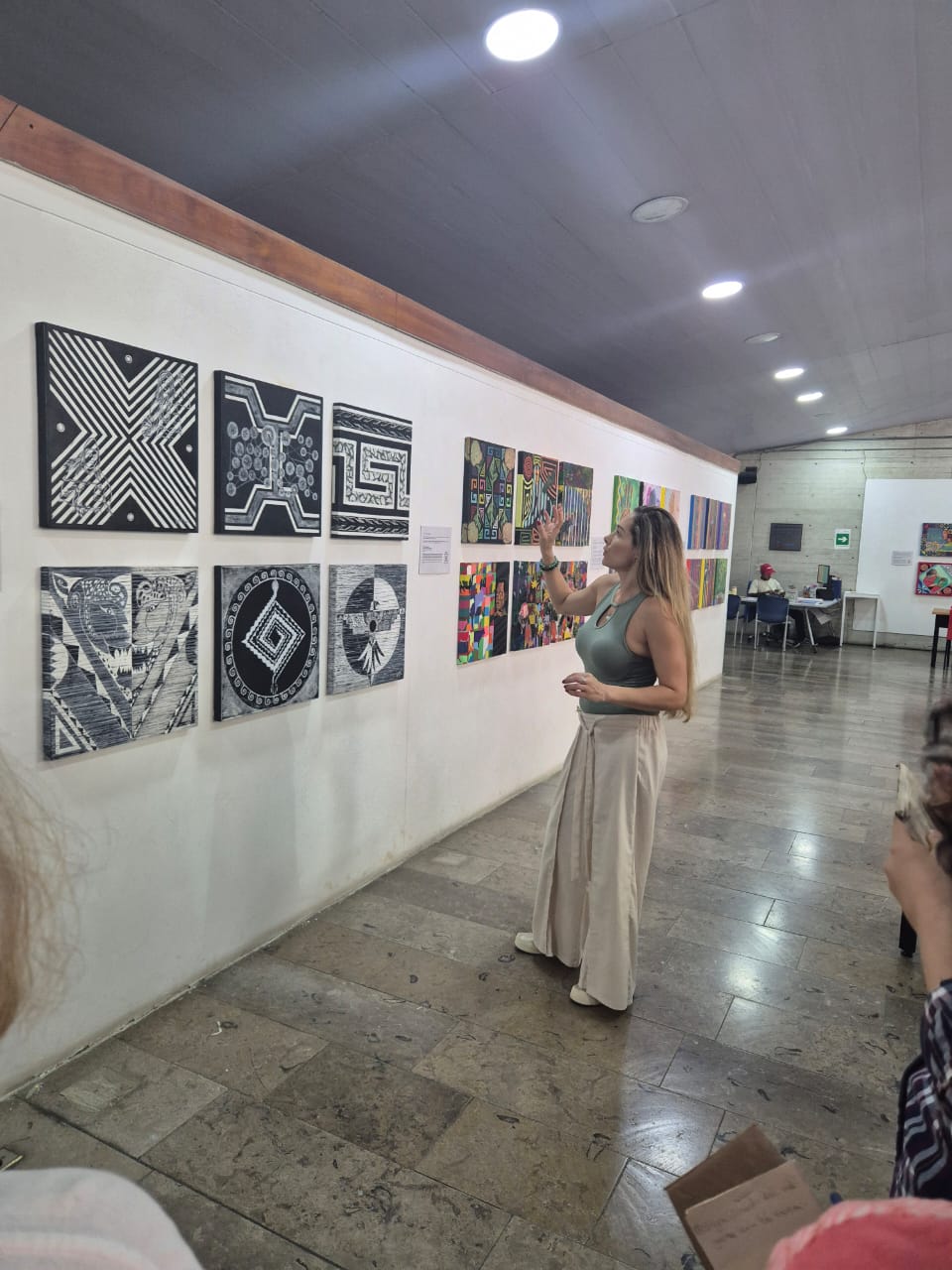 Yessie Morales observando obra expuesta